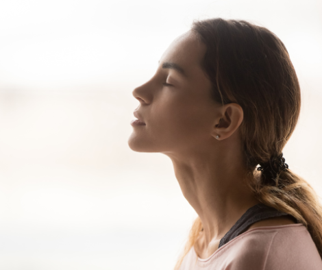 Woman in profile with eyes closed practicing mindfulness or deep breathing