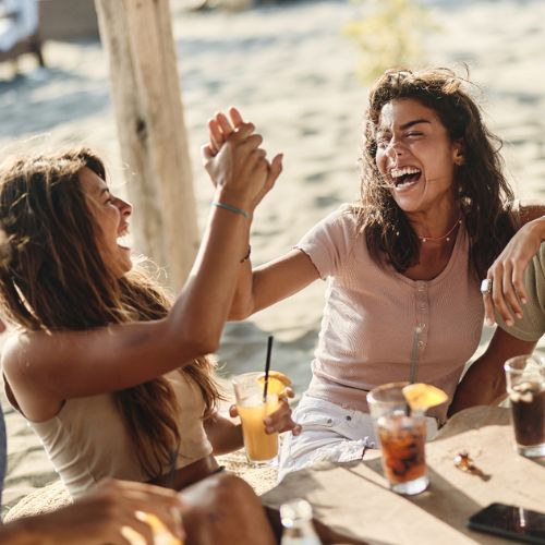 Group of women laughing together outdoors representing friendship and support