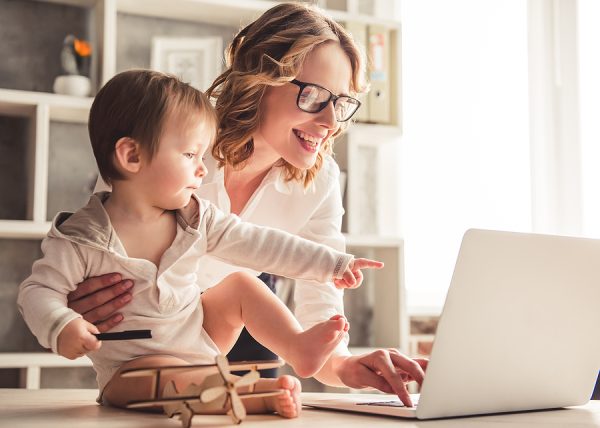Parent and child sitting together using a laptop at home
